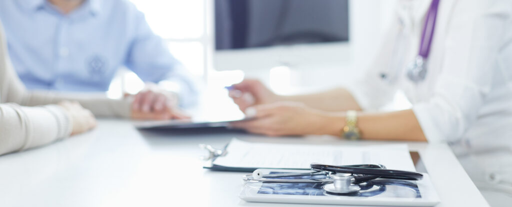 Attentive senior doctor listenint to patient in her office