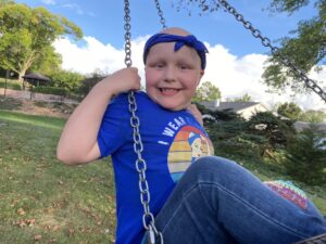 Girl with alopecia areata on a swing.