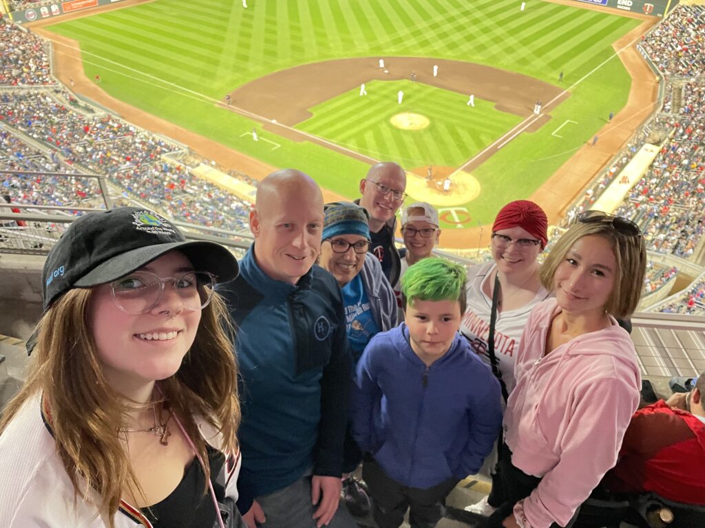 Person with alopecia areata at a ballgame.