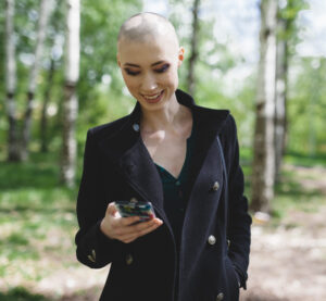 woman with alopecia areata using cell phone 